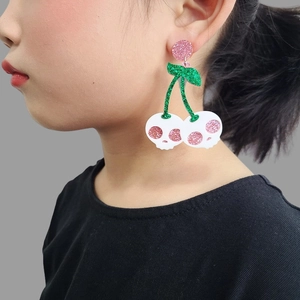 Halloween skull cherry earrings with pink and green glitter design worn by model