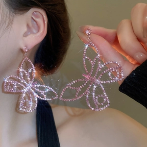 Detail shot of large pink rhinestone butterfly earrings with sparkling crystal accents