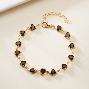 Detailed view of golden chain bracelet with black heart charms and adjustable lobster clasp