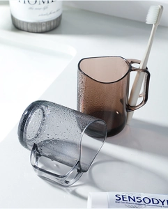 Detail of transparent gray and amber plastic mouthwash cups with toothbrush holder handles
