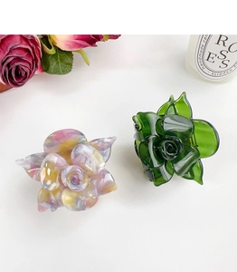Detail of floral acetate hair claws in marble multicolor and translucent emerald green