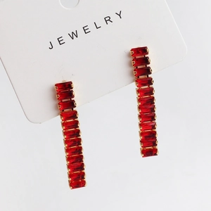 Close-up of elegant red rectangular gemstone drop earrings on a white jewelry card