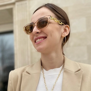 Cat eye sunglasses featuring transparent champagne frames and gold chain-link metal temples