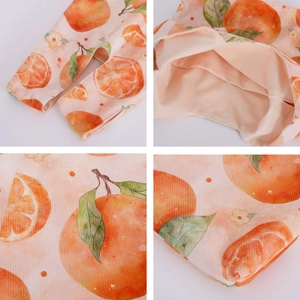 Detailed views showing orange fruit prints and peach lining of this soft velvet wrist bag