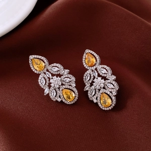 Elegante Vintage-Ohrhänger mit gelben und klaren Strasssteinen auf braunem Satinhintergrund