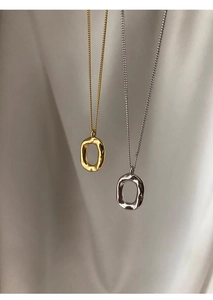 Close-up of gold and silver oval donut pendants with organic melted texture details