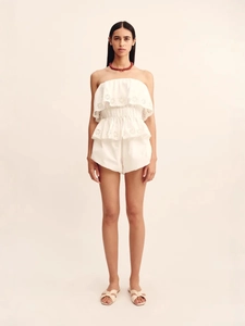 Detail of white two-piece set featuring eyelet embroidery and layered ruffle crop top