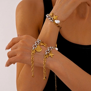 Marine charm bracelet with starfish, seashell pendants and pearls on gold-silver link chain