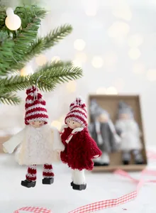 Christmas wool felt angel ornaments hanging on tree branch with warm festive bokeh lights