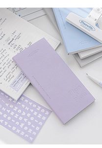 Flat lay of lilac PU leather daily planner with white binder clip and stationery