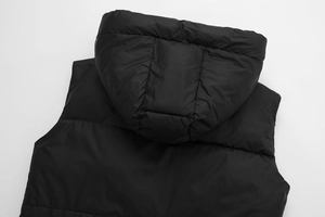 Detail view of black hooded vest showing high-quality quilting and polyester fabric texture