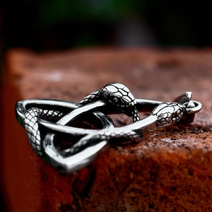 Viking Celtic knot pendant with intertwined snakes on a rustic stone background