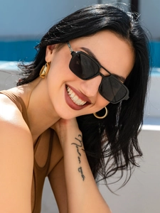 Outdoor close-up of a model wearing stylish black square sunglasses with dark lenses