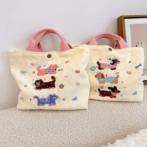 Détail de sacs cabas en velours côtelé avec broderie chat et chien et anses en coton