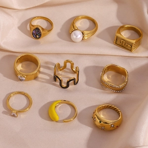 Detailed set of nine gold-plated rings with zircon and colorful enamel on pink silk