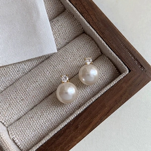 Detailed close-up of S925 silver pearl stud with sparkling crystal on a jewelry box