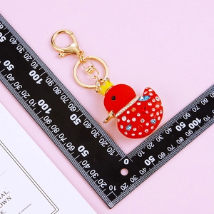 Detail of red duck keychain with sparkling rhinestones and golden crown charm