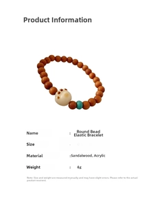 Detail of sandalwood beaded bracelet featuring a white acrylic cat paw charm and teal bead
