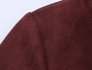 Detailed macro view of deep red suede fabric texture and stitching on the jacket shoulder