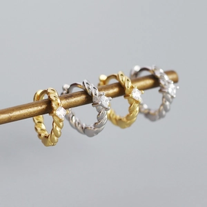 Detail of s925 silver twisted hoop earrings with square zircon in gold and silver finish