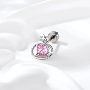 Elegant silver Saturn earring with pink zircon, macro view on white fabric background