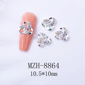 Détail de bijoux d'ongles en forme de trèfle argenté avec des strass brillants