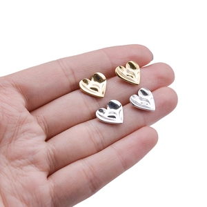 Detailed view of polished heart-shaped earrings in gold and silver finish set of four