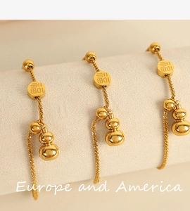 Detailed macro view of gold-plated Fu character disc and gourd charm on woven metal chains