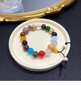 Close-up of colorful weathered Bodhi seed bracelet on a display tray with mixed beads