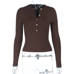Macro view of ribbed knit texture and white buttons on a brown long sleeve top
