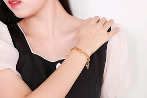 Close-up of double-layer gold beaded chain bracelet worn on wrist for a layered look