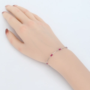 Detail view of 925 silver bracelet with four rectangular red gemstones on a model hand