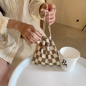 Primer plano del bolso de cordón con cuadros marrones y beige en tela de punto suave