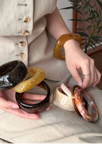 Close-up of stylish irregular resin bangles in amber, tortoiseshell and marble patterns
