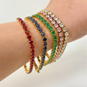 Détail de bracelets tennis en acier doré 18 carats avec des pierres de zircon colorées