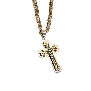 Close-up of layered cross pendant in black and gold on a two-tone stainless steel chain