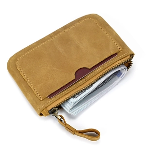 Detail of a brown genuine leather coin purse with three zippers and a built-in keyring