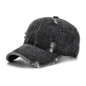 Macro detail of distressed black washed denim texture and frayed holes on baseball cap
