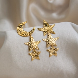 Detail view of 18K gold plated asymmetrical star moon earrings with hammered texture
