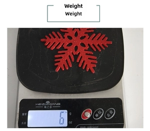 Weight measurement of a 10cm red glitter snowflake decoration on a digital scale