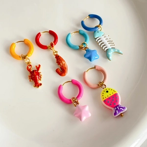 Detailed close-up of colorful ocean-themed drop earrings with lobster and seahorse charms
