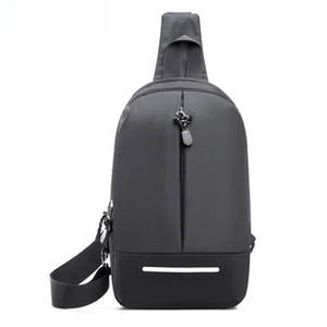 Detail of waterproof nylon crossbody bag featuring grey panels and white reflective strip