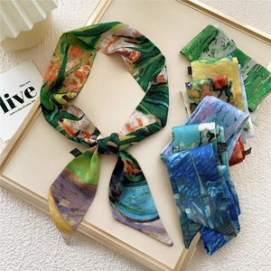 Impressionist art print skinny silk scarf tied in a bow on a stylish golden frame tray