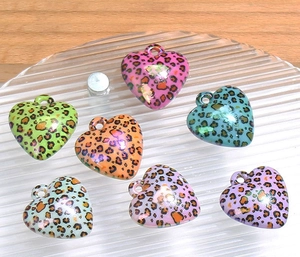 Detailed view of colorful leopard print heart charms with hanging holes for DIY crafts