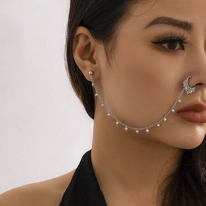 Detail of silver punk chain earring and nose ring link with faux pearls on model