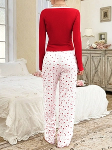 Detail of red ribbed top with delicate lace trim and crown print pajama trousers