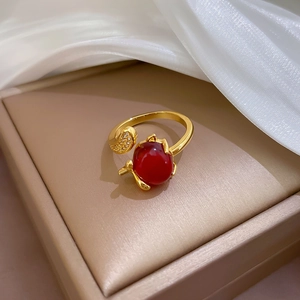 Detailed close-up of a red stone fox ring with cubic zirconia on a beige jewelry box