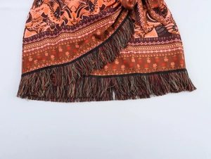 Detail view of Bohemian mini skirt with multicolor tassels and ethnic floral patterns