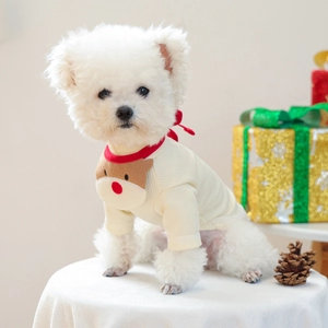 Detail of Christmas dog bandana with reindeer patch and red trim on soft white fabric