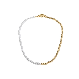 Minimalist pearl and gold bead necklace featuring a vintage OT toggle clasp on white background